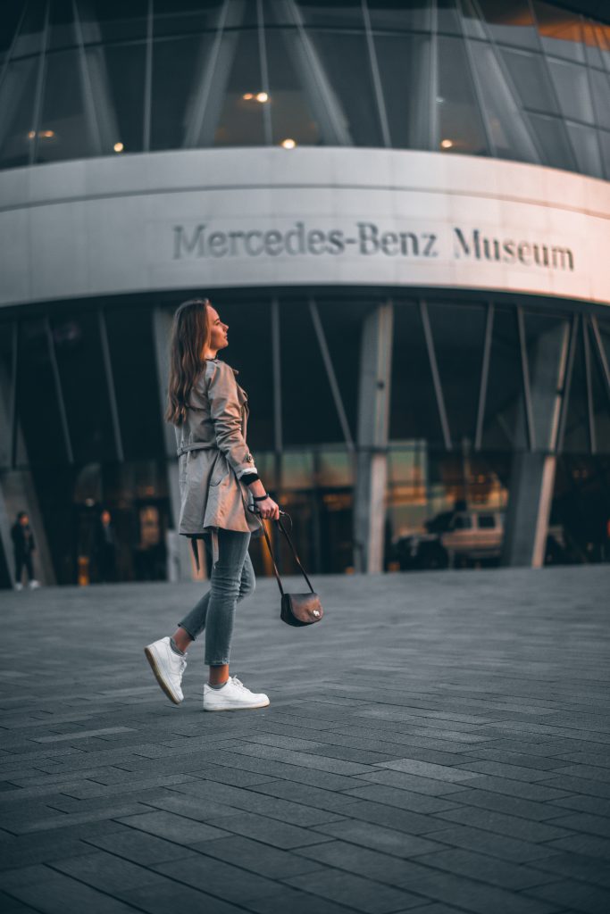 a woman in front of the mercedes benz showroom
