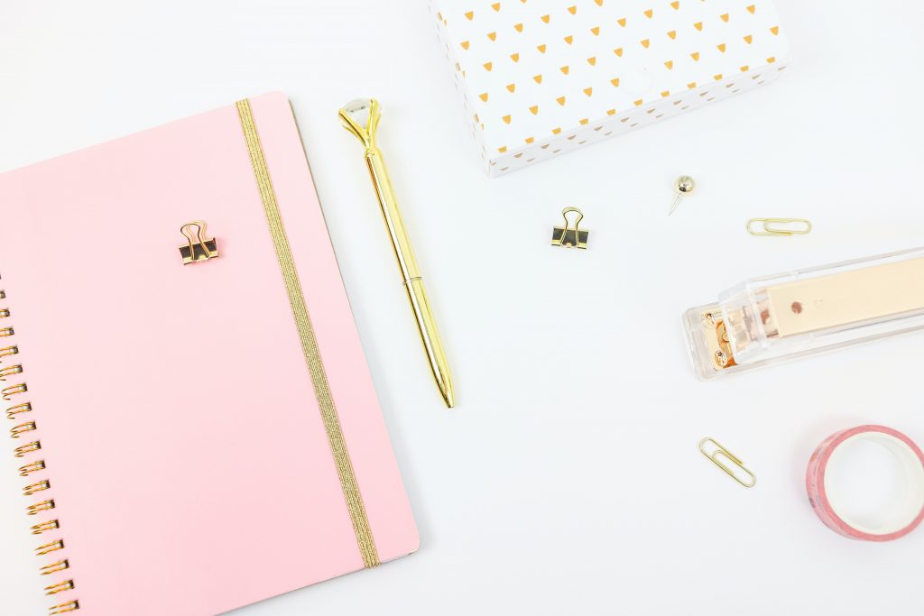 flatlay of a pink notebook and stationary