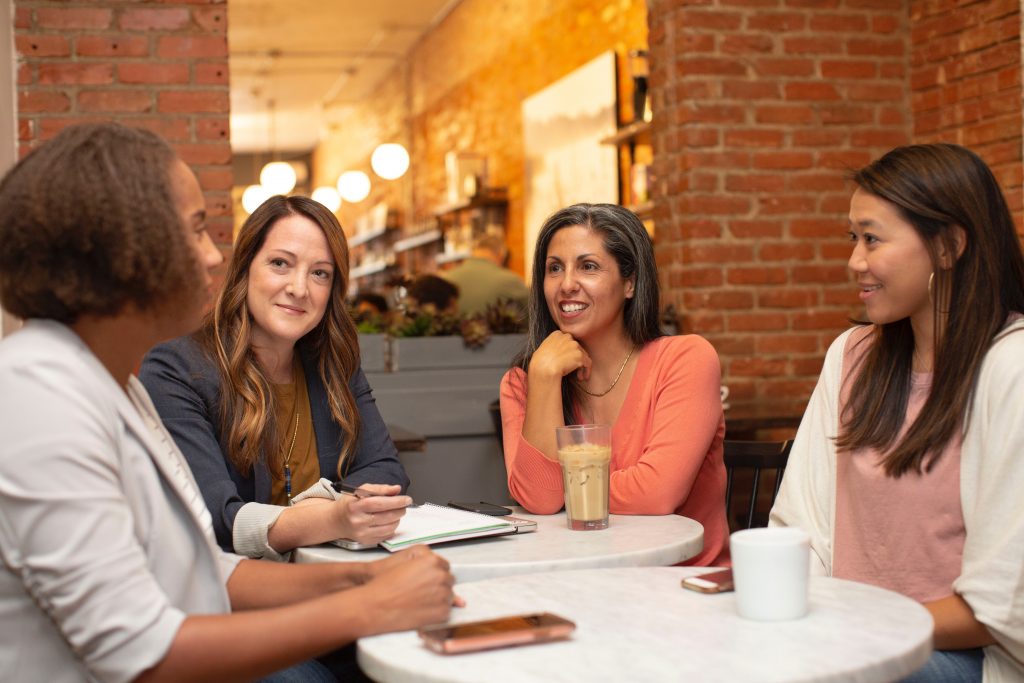 4 women talking around a table
