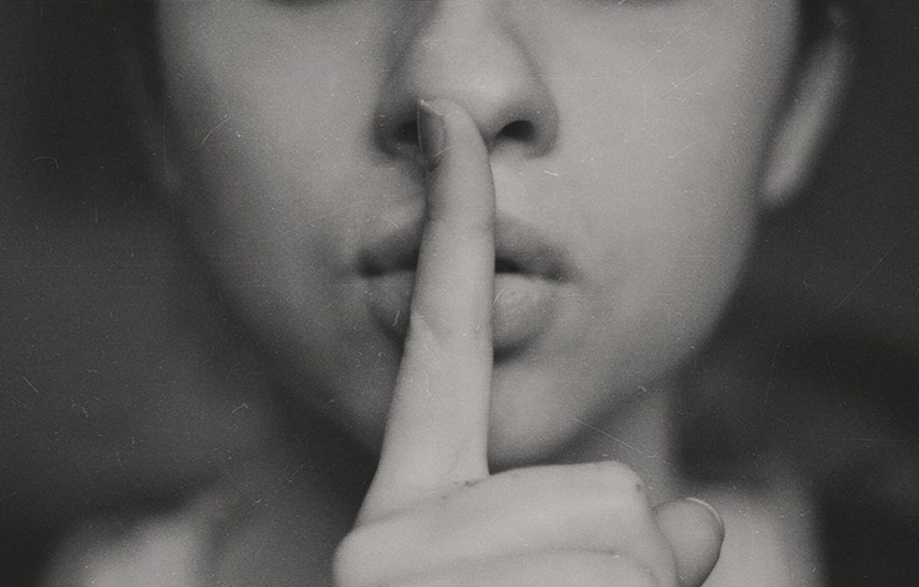 a woman putting her finger to her lips