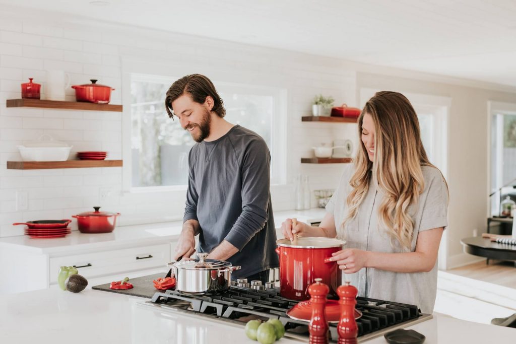 a man and woman happily cooking together 