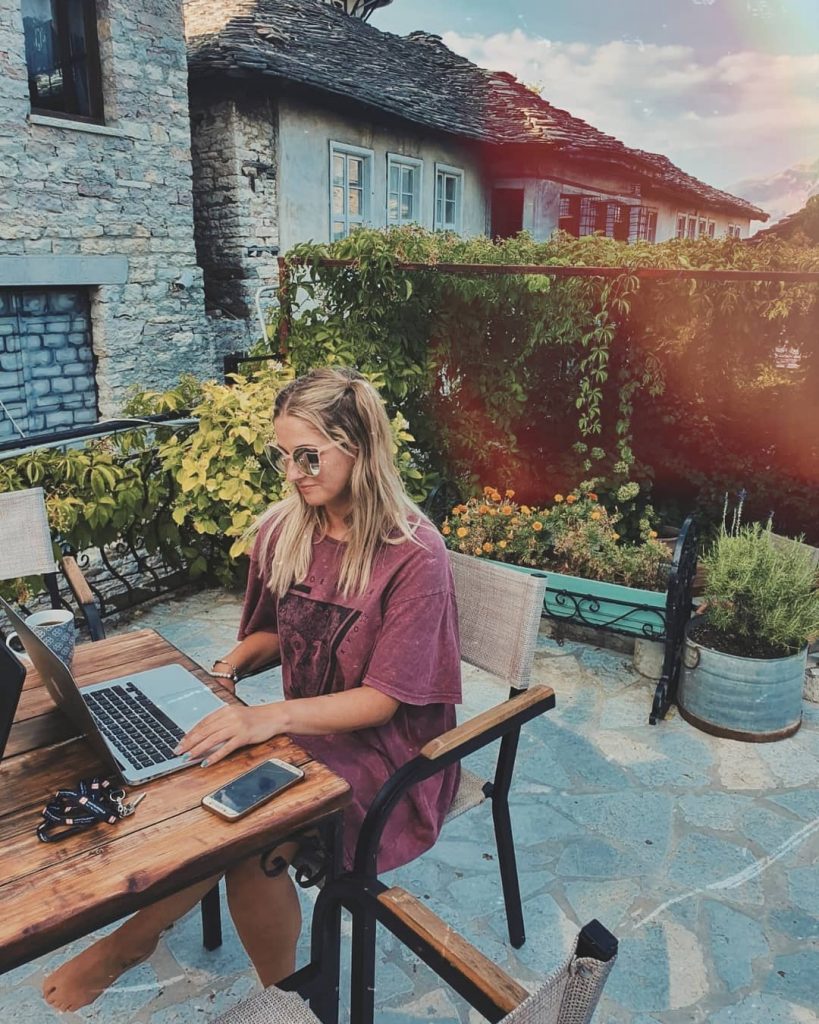 a girl on her laptop in a garden