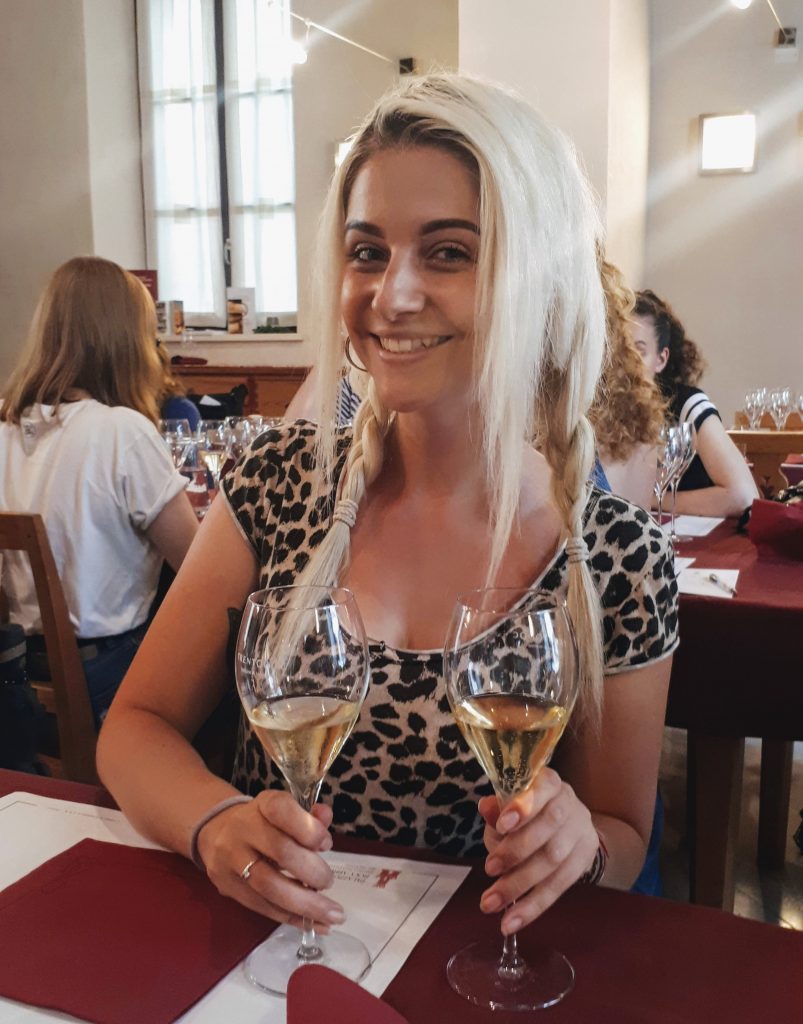 a girl holding 2 glasses of wine