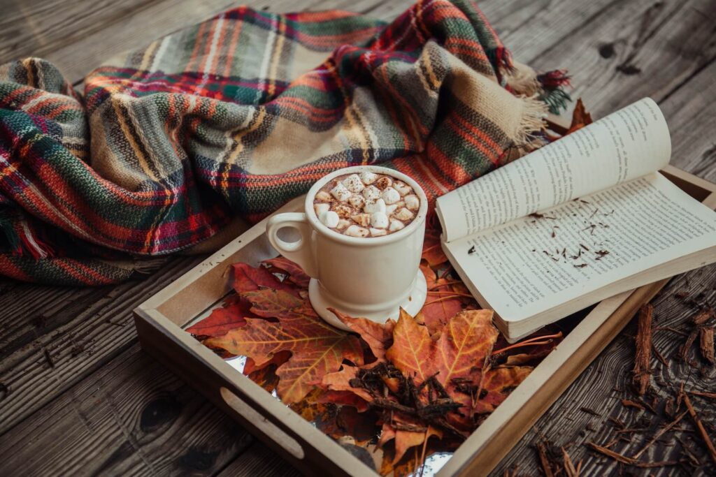 hot chocolate and a book with some autumn leaves