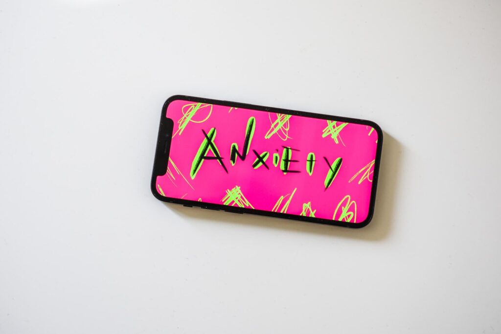 a phone with the word 'anxiety' on it in pink