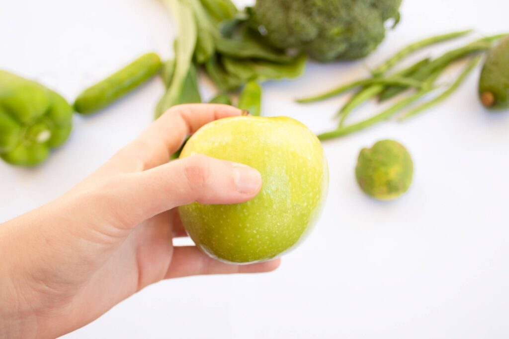 a hand holding an apple