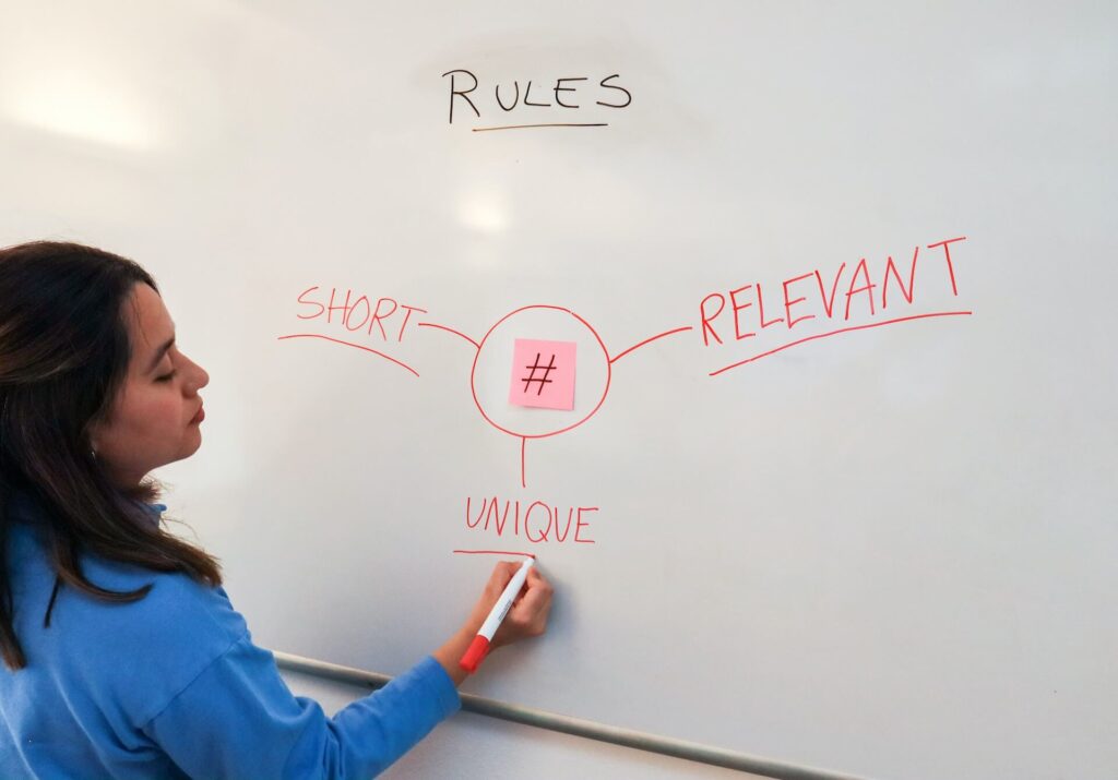 a woman writing the rules of a good hashtag on a whiteboard